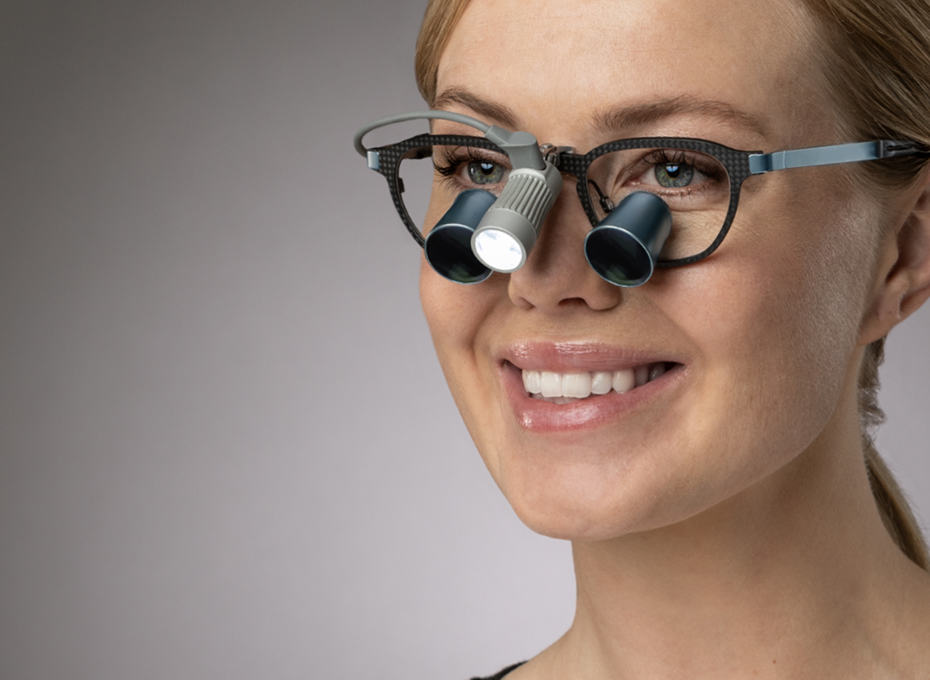 Female dentist wearing loupes with dental headlight Total attached