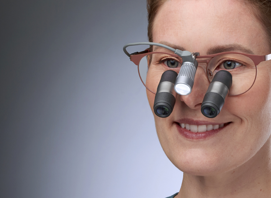 Smiling dentist wearing her loupes glasses Kepler Advanced in a Panto frame with a Total LED